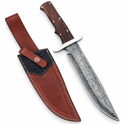Bowie knife in Damascus steel with wood handle and cross guard beside leather sheath
