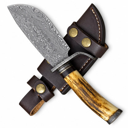 Antler handle knife resting on a leather sheath with snap straps