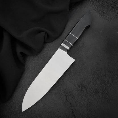 Chef knife for chopping with polished 440C blade and black Micarta handle on dark textured surface
