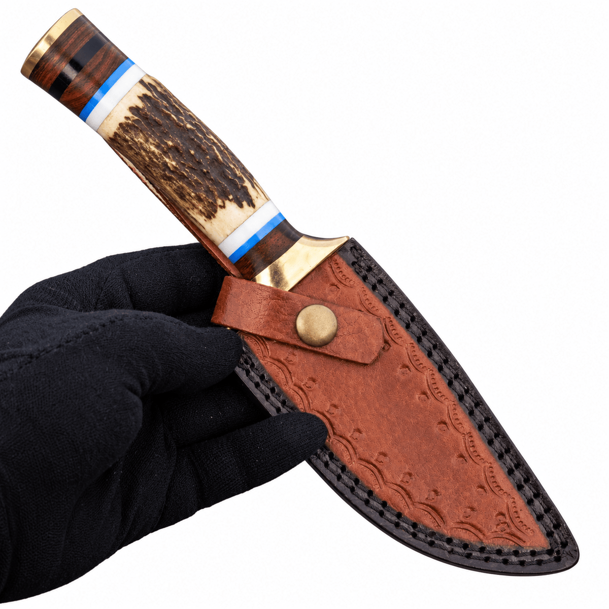 Tooled tan leather sheath with stitched border and belt loop beside a hunting knife