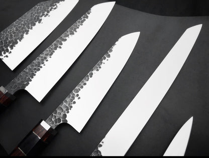 Five 440C kitchen knives from small paring size to long slicer laid out in a row
