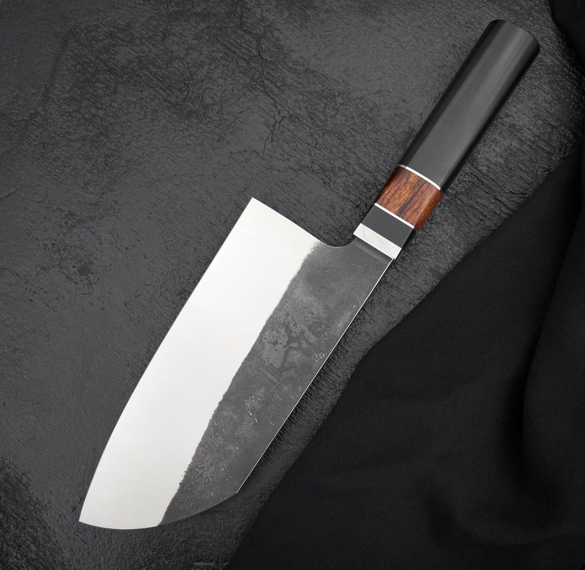 Handmade 6.5 inch kitchen knife with polished edge side and dark textured finish above

