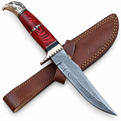 Handmade Damascus knife with eagle head pommel next to its leather sheath