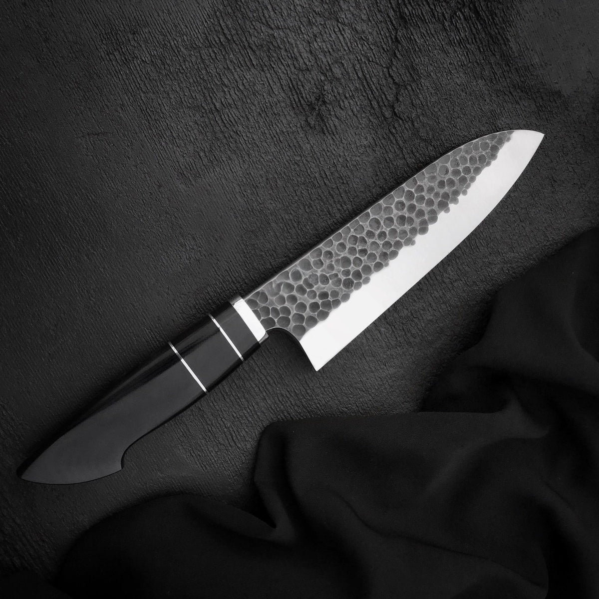 Black Micarta knife handle with two thin light spacers and polished metal collar
