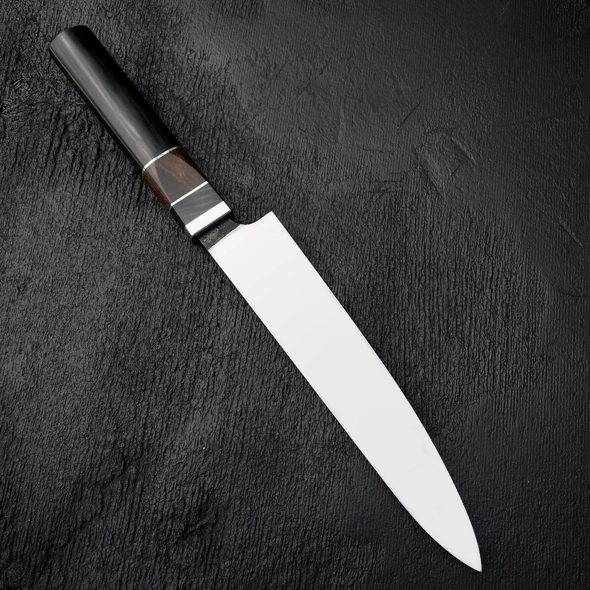 Octagonal knife handle with black Micarta, dark wood section and thin light spacers
