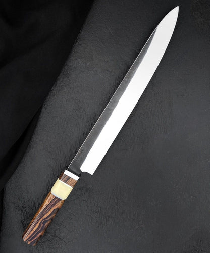 Meat slicer knife with long polished blade and figured wood handle on black textured surface
