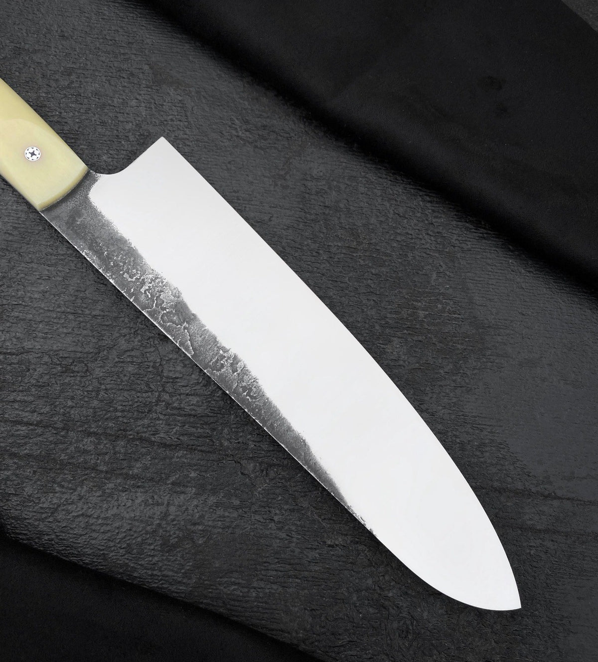 Handmade 8 inch kitchen knife with wide blade, curved tip and dark finish along the spine
