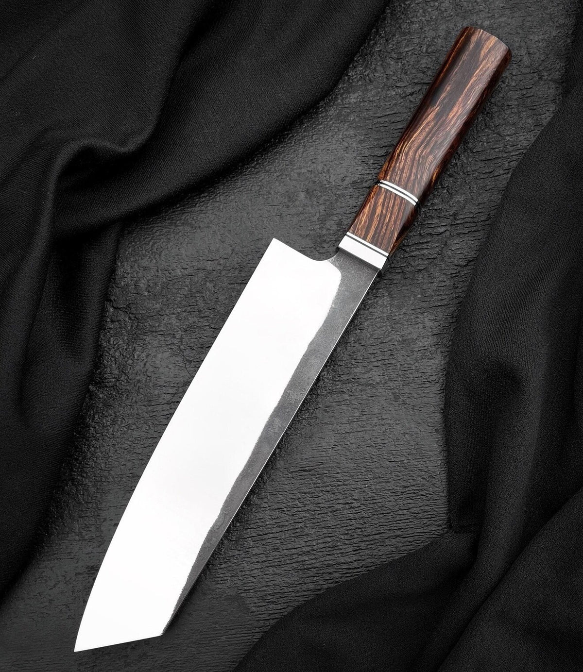 Kiritsuke chef knife with polished angled-tip blade and octagonal brown wood handle on black surface
