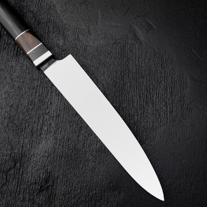 Long stainless steel kitchen slicing knife shown from above on dark background