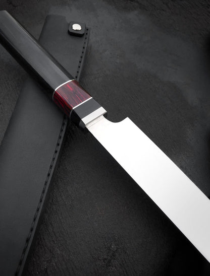 Long stainless steel slicing knife with resin and bone handle next to black fabric