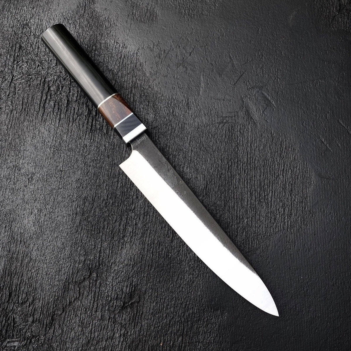 Slicer knife with slim 440C blade and octagonal Micarta and wood handle on black textured surface
